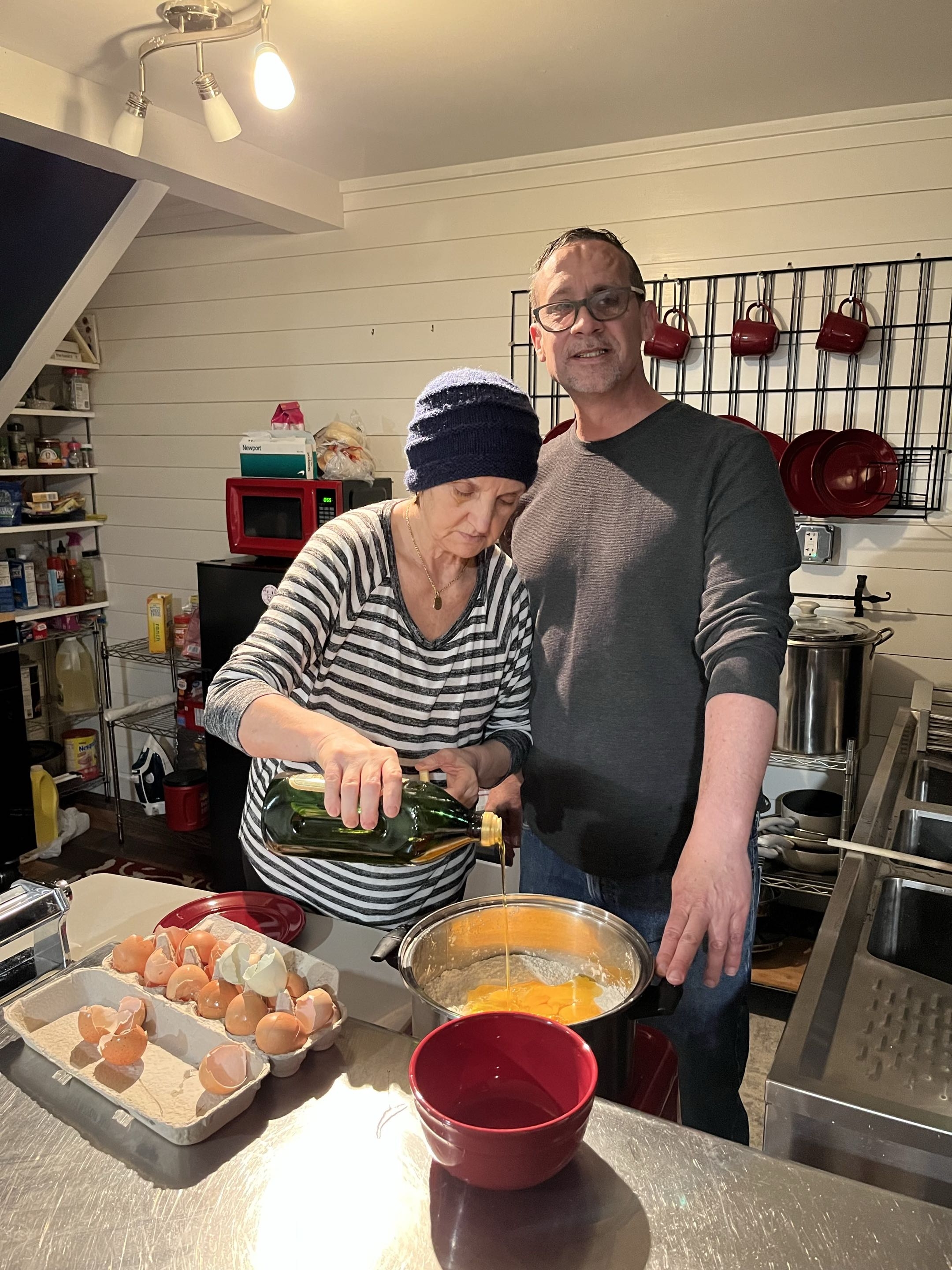 Nonna and Phil cooking together pouring olive oil